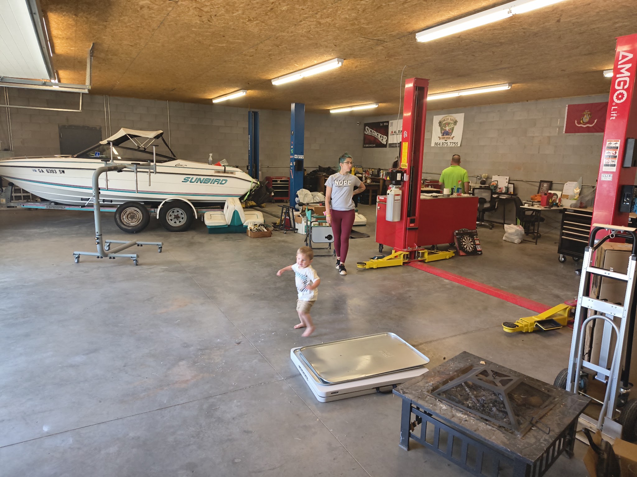 Our shop floor with two vehicle lifts and a boat on a trailer
